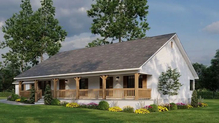 a small white house with porches and flowers in the front yard on a sunny day