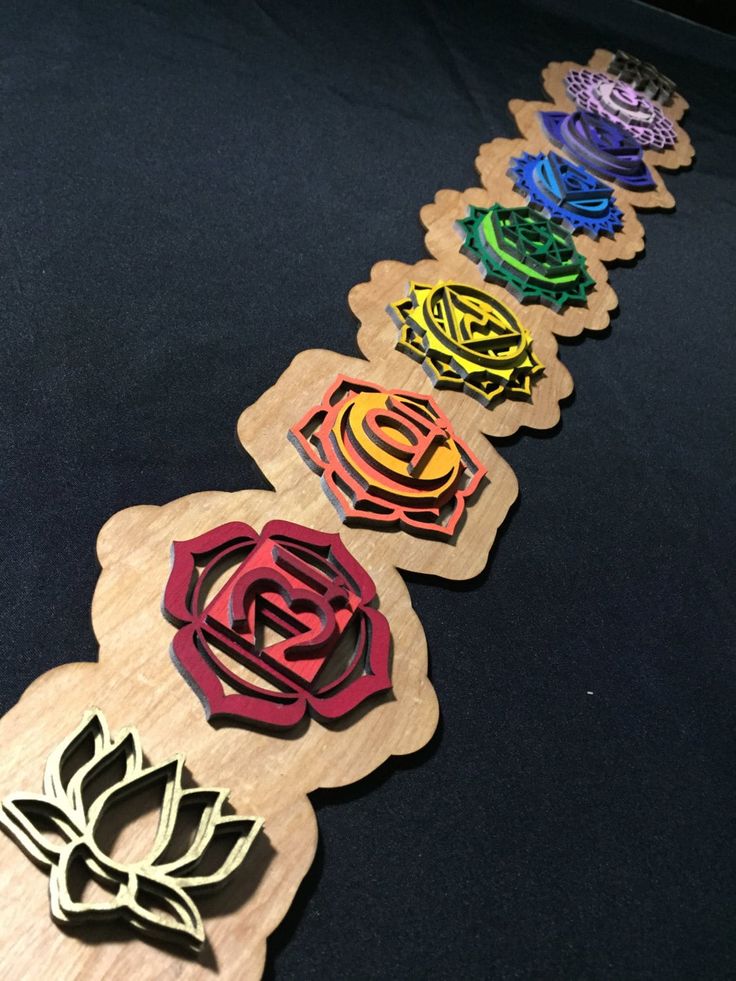 several wooden flowers are lined up on a black tablecloth, with one flower in the middle