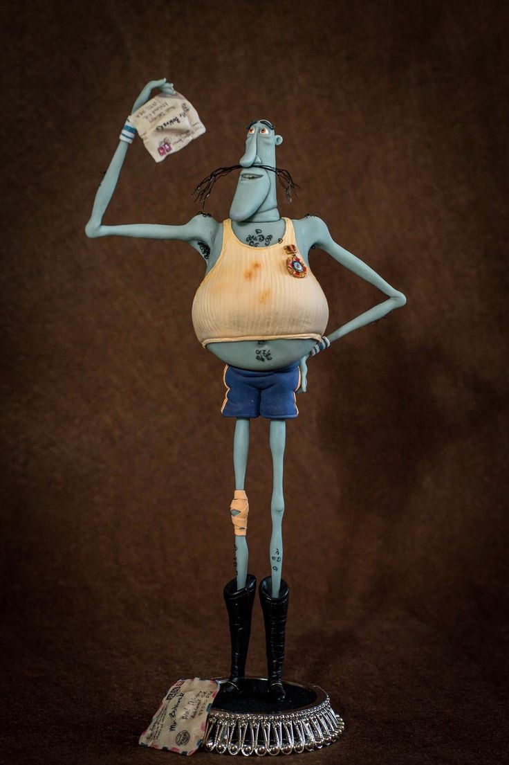 a blue alien figurine holding a piece of paper in one hand and a newspaper in the other