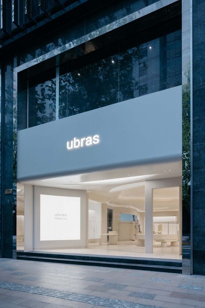 an urban store front with the words ubras illuminated in white on it's windows