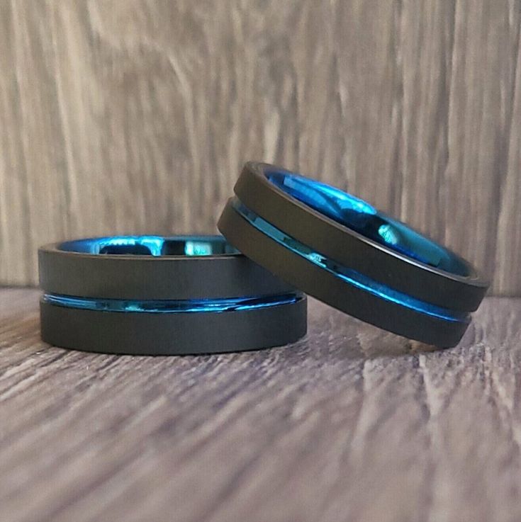 two rings with blue lights on them sitting on top of a wooden table next to each other