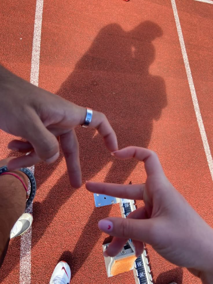 on red track with hand hearts Track And Field Couple Goals, Track Couple Pictures, Sport Couple Aesthetic, Track And Field Couples, Xc Couples, Couples Running Aesthetic, Running Couple Aesthetic, Couple Athlete, Couple Running Aesthetic