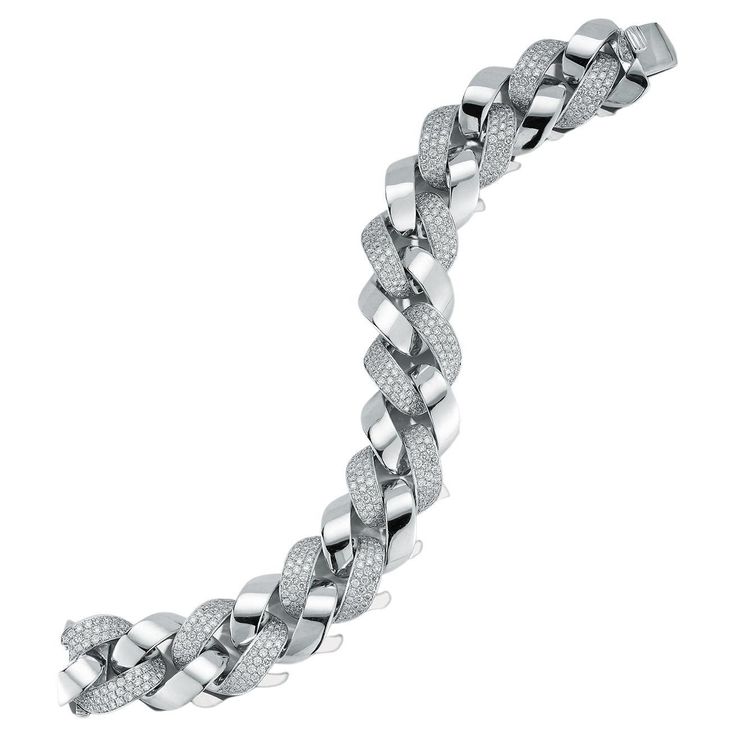 This exquisite Cuban link bracelet is a true statement piece that combines the luxury of white gold with the brilliance of diamonds. The bracelet is crafted from high-quality white gold, which has a bright and lustrous appearance that complements the diamonds perfectly. The bracelet features a classic Cuban link design, with interlocking links that create a bold and stylish look. Each link is adorned with a row of sparkling diamonds, which are expertly set to create a stunning display of light and brilliance. The diamonds used in this bracelet are of the highest quality, with a stunning clarity and brilliance that is sure to turn heads. The bracelet is designed to fit comfortably on the wrist, with a secure clasp ensuring that it stays in place all day long. This white gold and diamond Cub Luxury White Gold Cuban Link Bracelet With Diamond Cut, Luxury Diamond White Cubic Zirconia Chain Bracelet, Luxury Diamond Cut White Gold Cuban Link Bracelet, Iced-out Cuban Link Bracelet In White Gold, Luxury Iced-out Cubic Zirconia Chain Bracelet, Gold Cuban Chain, Cuban Chain Bracelet, Cuban Link Bracelet, Link Design