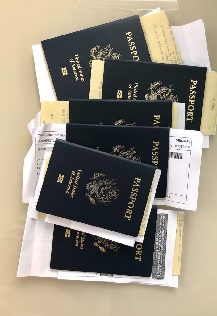 three passports sitting on top of each other next to envelopes and paper towels in front of them