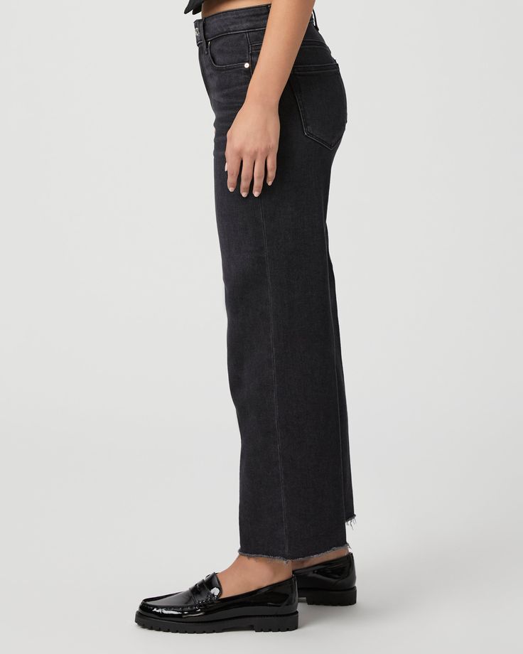 This modern high-waisted wide leg has an easy, relaxed fit and an ankle length silhouette. This style is cut from our PAIGE Vintage denim and comes in a vintage black wash with whiskering, fading, and a raw hem. PAIGE Vintage takes all of the work out of breaking in your favorite pair of vintage jeans. We've combined the comfort of stretch with everything you love about authentic vintage denim to create super soft jeans that feel perfectly lived-in from the very first wear. | Anessa Wide Leg Jea Black High-rise Cropped Jeans With Frayed Hem, High Rise Black Cropped Jeans With Frayed Hem, Black High Rise Cropped Jeans With Frayed Hem, Fall Wide Leg Cropped Jeans With Frayed Hem, Wide Leg Cropped Jeans With Frayed Hem For Fall, Black Cropped Jeans With Frayed Hem For Fall, Trendy Black Cropped Jeans With Frayed Hem, Black Wide Leg Flare Jeans With Frayed Hem, Washed Black High-rise Flare Jeans With Frayed Hem