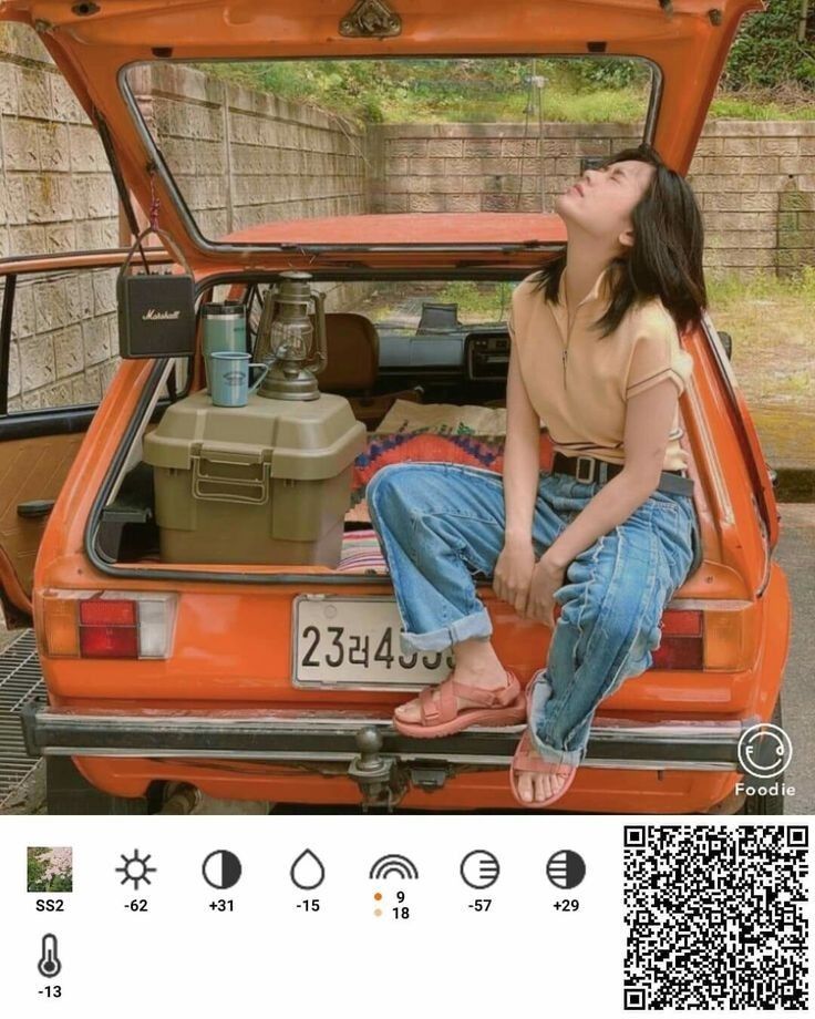 a woman sitting in the back of an orange car