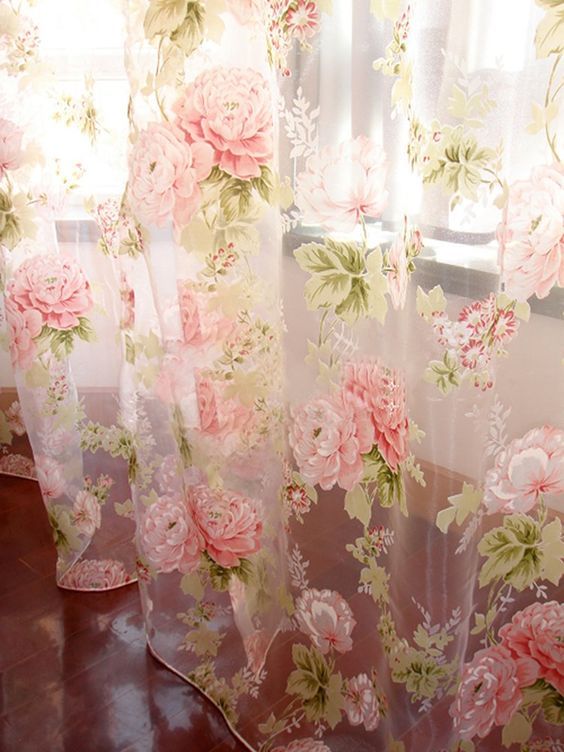 the curtains are covered with pink flowers