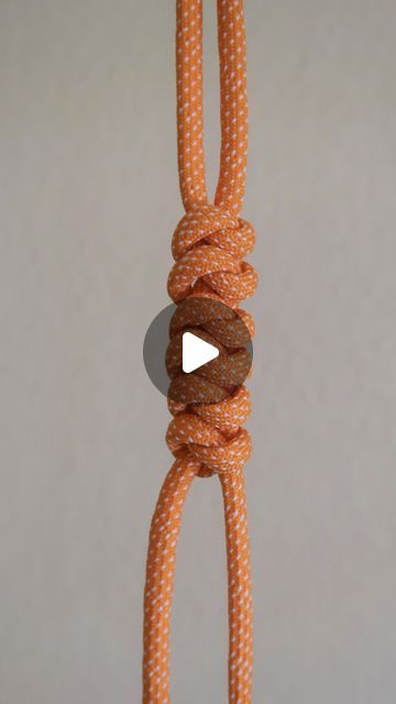 an orange rope with two donuts hanging from it's end and a white button on