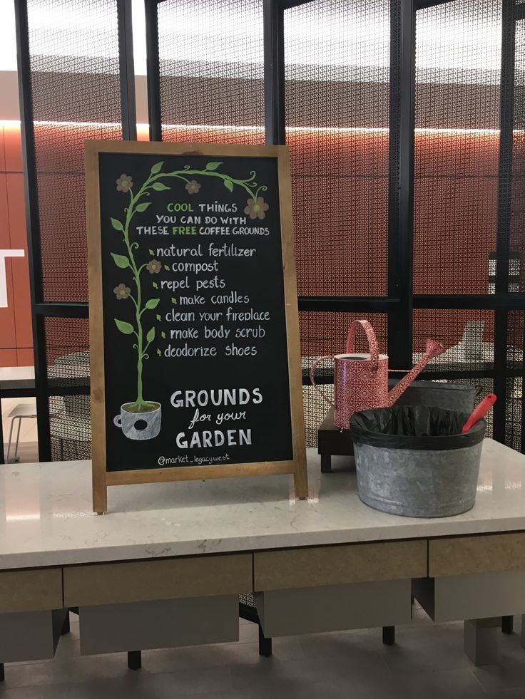 a table with a sign and potted plant on it next to a bucket full of dirt