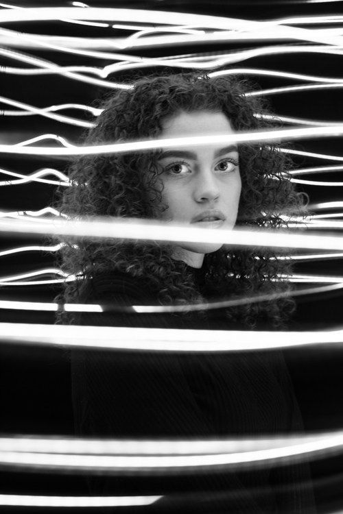 a woman with curly hair looking at the camera