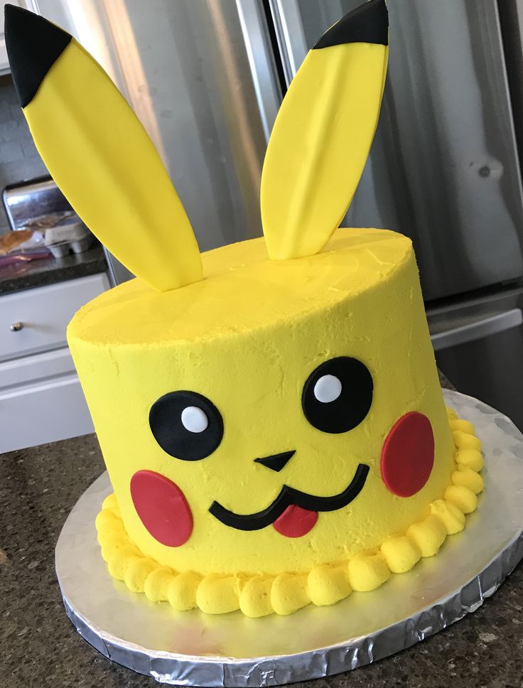 a yellow cake decorated like a pikachu with ears on it's head