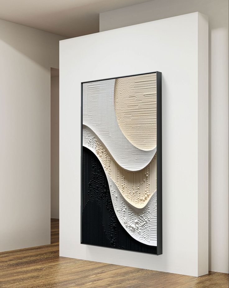 an abstract art piece hangs on the wall next to a wooden floor in a white room