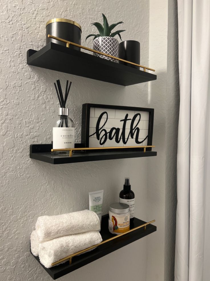 two bathroom shelves with towels and other items on them