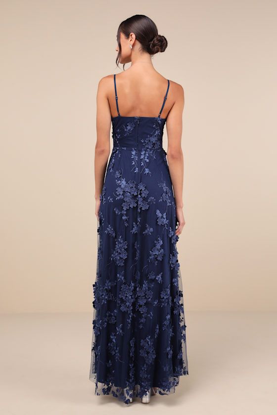 The Lulus Rare Presence Navy Blue 3D Floral Surplice Maxi Dress is the perfect look to celebrate any grand occasion! This elegant dress boasts a sheer mesh overlay, adorned with tonal floral embroidery and floral applique details (some of which have a 3D effect to them), that shapes a flattering princess-seamed bodice, a flirty surplice neckline, and adjustable spaghetti straps. The high, fitted waist sits atop a flowy, A-line skirt that cascades down to a sweeping maxi hem with an alluring side slit. Hidden back zipper/clasp. Fit: This garment fits true to size. Length: Floor length. Size medium measures 55" from adjustable straps to hem. Bust: Great for any cup size. Waist: Fitted - very fitted at natural waist. Hip: Not Fitted - fuller skirt allows room for hips. Undergarments: May be w Blue Beaded Bridesmaid Dress, Navy Blue Dresses Long, Navy Floral Bridesmaid Dresses, Formal Dress Navy, Prom Dress Inspo Sparkly, Unconventional Prom Dress, Dark Blue Wedding Guest Dress, Dreamy Prom Dress, Blue Flowy Maxi Dress