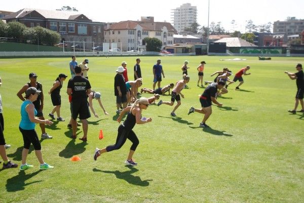 a group of people on a field with frisbees in their hands and one person running