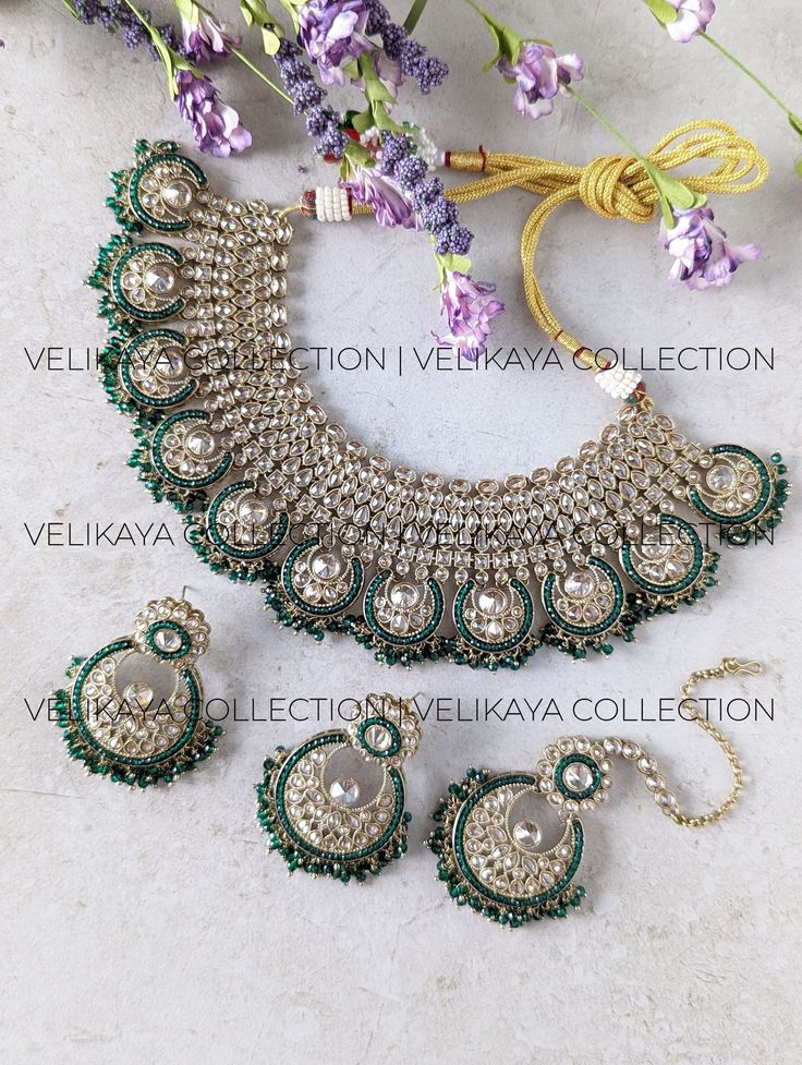 This beautiful emerald green bridal set consists of a statement necklace, earrings and maang tikka. Necklace plating is antique gold. Sparkling champagne stones with superior craftsmanship. Perfect for Indian and Pakistani weddings. Product Details: * Necklace -  Comes with adjustable zari cord.  * Earrings - For pierced ears. Length: 6 cm, Width: 4.5 cm approx * Maang Tikka Buy bridal bangles, chuda / choora and kalira here: https://www.etsy.com/ca/shop/VelikayaCollection?section_id=32318583 https://www.etsy.com/ca/shop/VelikayaCollection?section_id=36242466 Check out our collection of nose-rings, pasa, haathphool and hair accessories: https://www.etsy.com/ca/shop/VelikayaCollection ----------- CARE ----------- - Store in air tight zip lock bags - Do not expose to moisture/water - Do not Green Hand Set Chandbalis For Festivals, Green Bridal Earrings For Reception On Diwali, Green Bridal Earrings For Reception During Diwali, Green Bridal Earrings For Reception At Diwali, Festival Green Hand Set Chandbalis, Green Hand Set Chandbalis For Diwali, Green Chandbalis For Diwali Reception, Green Chandbalis For Reception And Diwali, Green Lehenga With Stone Work For Reception