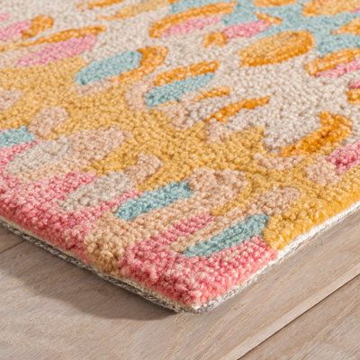 a multicolored area rug on a wooden floor with a wood floor in the background