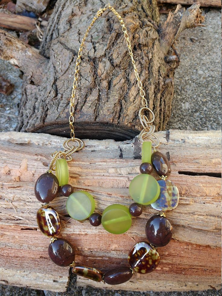 An exotic, vintage chain inspired me to craft a set of necklace and earrings that would do just to the complexity of it's links. Combining 1 inch twisted links with the vintage gold chain, green resin circles, brown resin faux stone beads and green and brown ceramic beads sporting gold bead caps, adds drama and interest to this original work of art. The necklace measures 24 inches in length and 28 inches with the drop.  The earrings are 1.5 inches in length and feature gold ear wires, brown round beads and gold bead caps. A gold spring ring clasp completes the necklace. Original and handmade using recycled and new pieces. Each item or set arrives individually gift boxed for your convenience. #S003 Vintage Brown Jewelry With Adjustable Chain, Vintage Brown Jewelry With Chain, Brown Metal Chain Jewelry, Green Wire Wrapped Czech Glass Necklace, Handmade Brown Glass Jewelry, Earthy Gold Dangle Jewelry, Elegant Brown Brass Necklace, Green Metal Necklace With Adjustable Chain, Green Metal Chain Necklace With Adjustable Chain