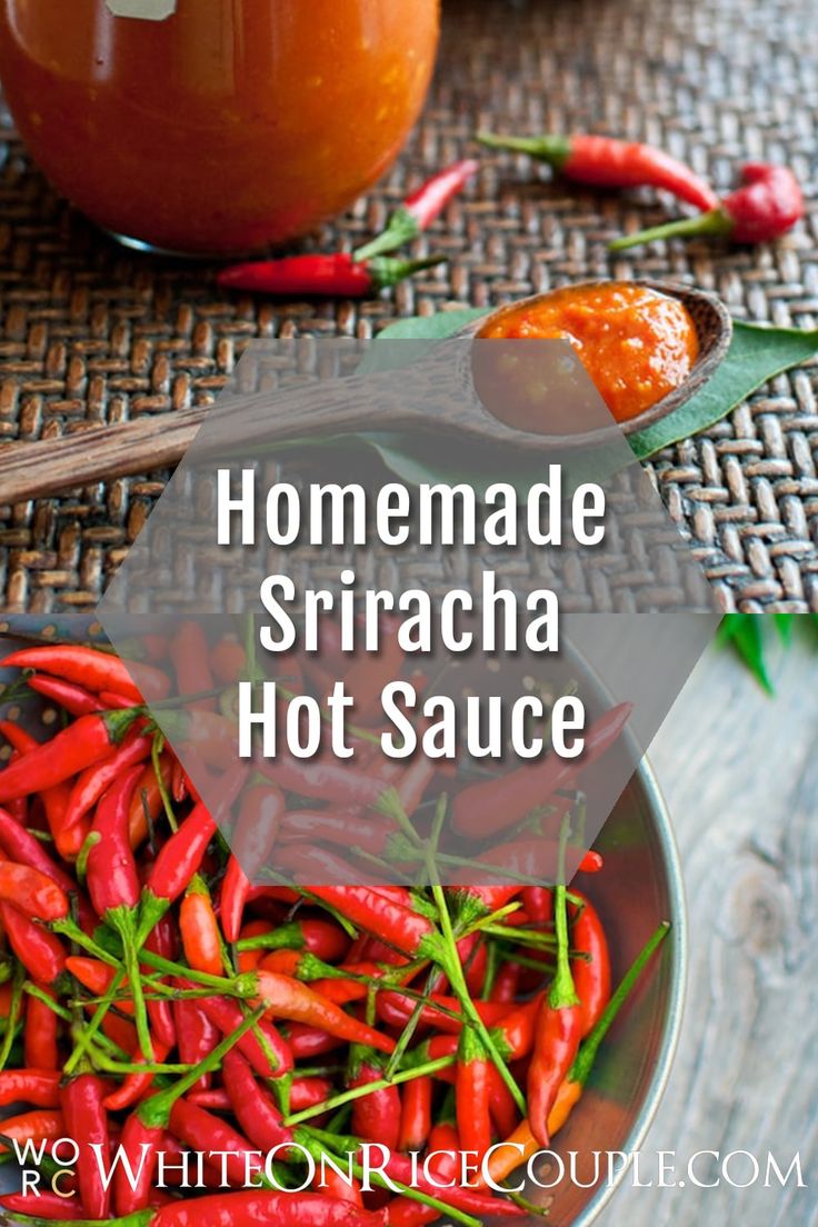 homemade sriraca hot sauce in a glass bowl with red peppers on the side