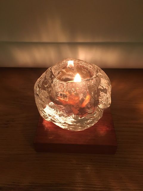 a glass candle holder on a wooden table