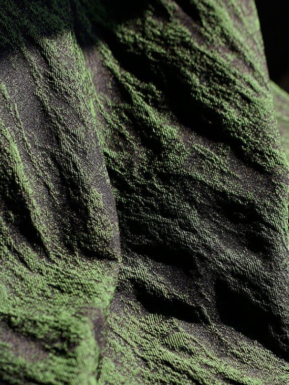 a close up view of the textured fabric on a bed sheet that is green and black