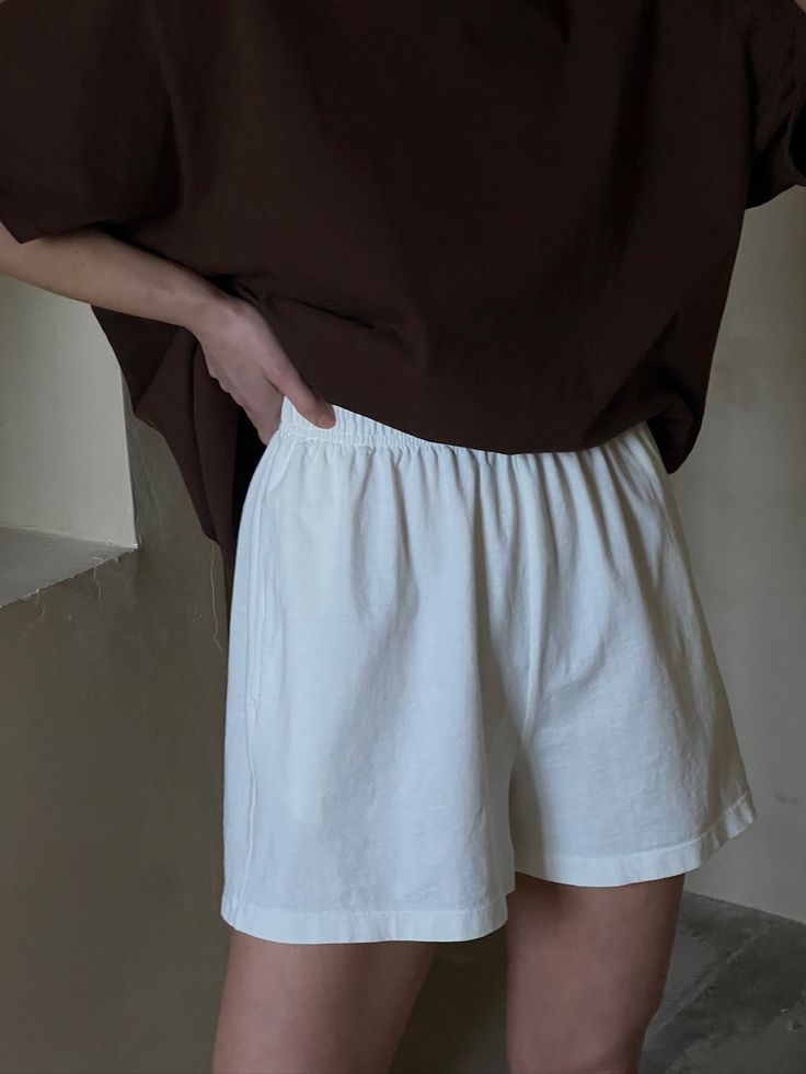 The Na Nin Nina Vintage Cotton Shorts are a must-have for any wardrobe. Made from 100% cotton, these shorts have a luxuriously soft feel and a true vintage aesthetic. This fresh iteration includes a comfortable elastic waistband with a drawstring, convenient side pockets, and a flattering yet relaxed fit. Perfect for any occasion, these versatile shorts are a staple piece that you won't want to miss. 100% Cotton Made in USA Alabaster - White Faded Black - Black Measurements: XXS: 20" - 24" waist Casual Bermuda Shorts With Built-in Shorts For Daywear, Comfortable Solid Cotton Shorts, Relaxed Bottoms With Built-in Shorts For Spring, Relaxed Shorts With Pockets For Day Out, Cotton Summer Bottoms With Relaxed Fit, Relaxed Cotton Bottoms For Summer, Comfortable Summer Bottoms Short Length, Comfortable Summer Shorts, Casual High Waist Cotton Bermuda Shorts