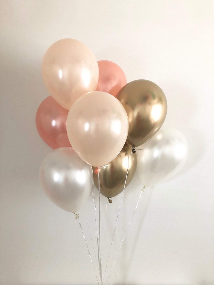 a vase filled with balloons on top of a table