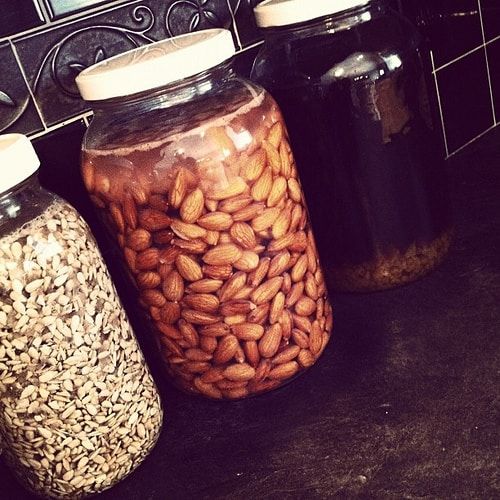 three jars filled with nuts sitting on top of a counter