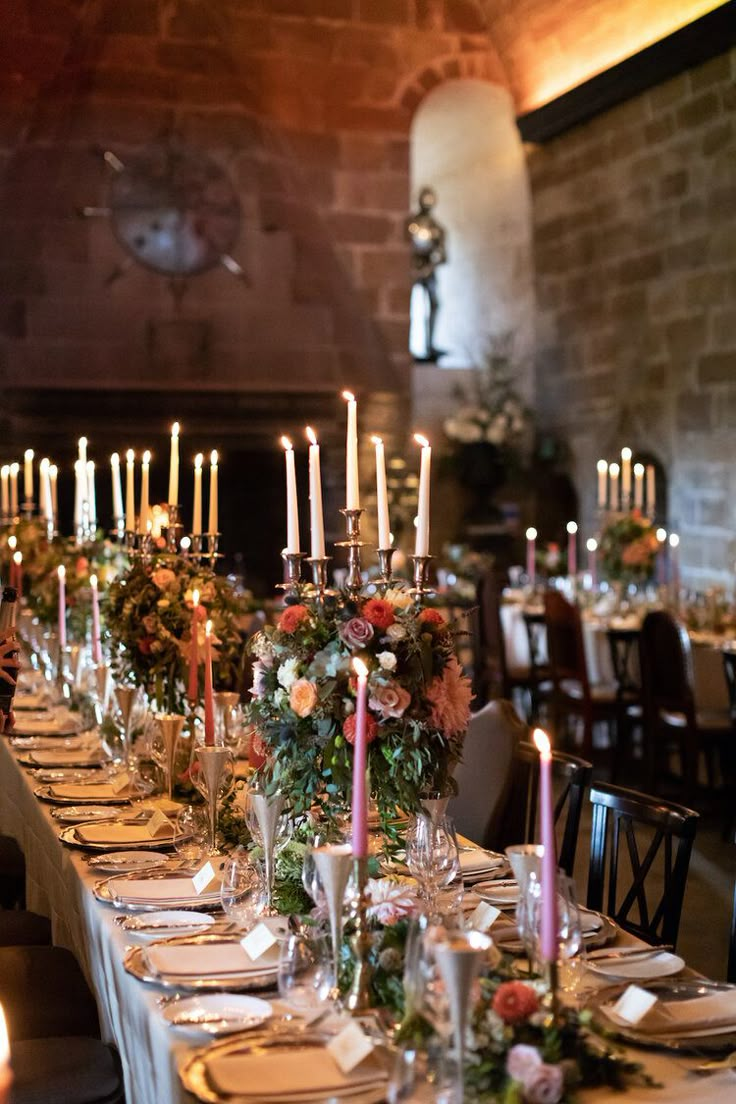 a long table is set with candles and flowers for an elegant dinner or party event