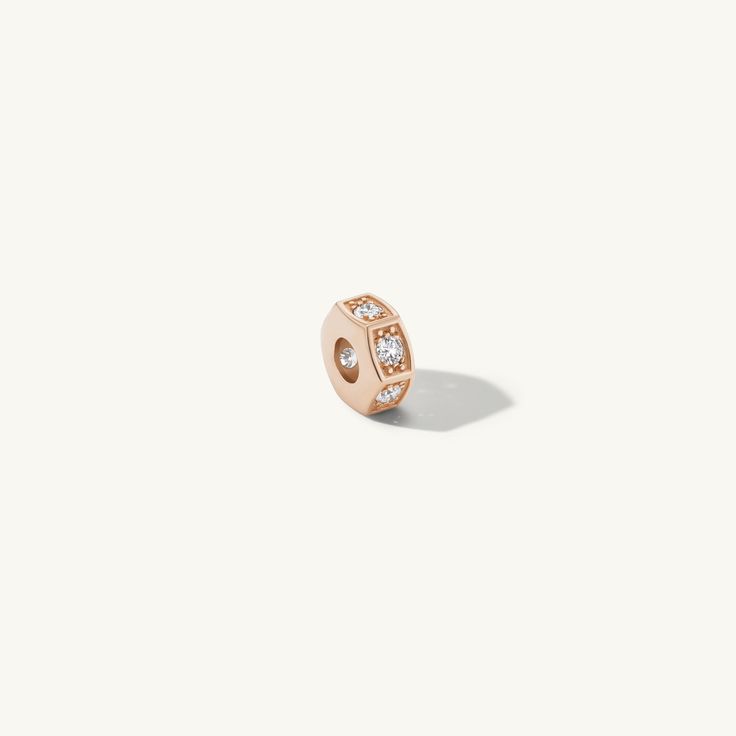 a rose gold ring with diamonds on the front and side, set against a white background