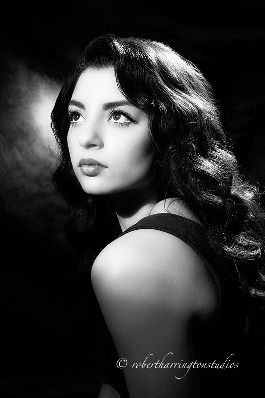 a black and white photo of a woman with long dark hair looking at the camera