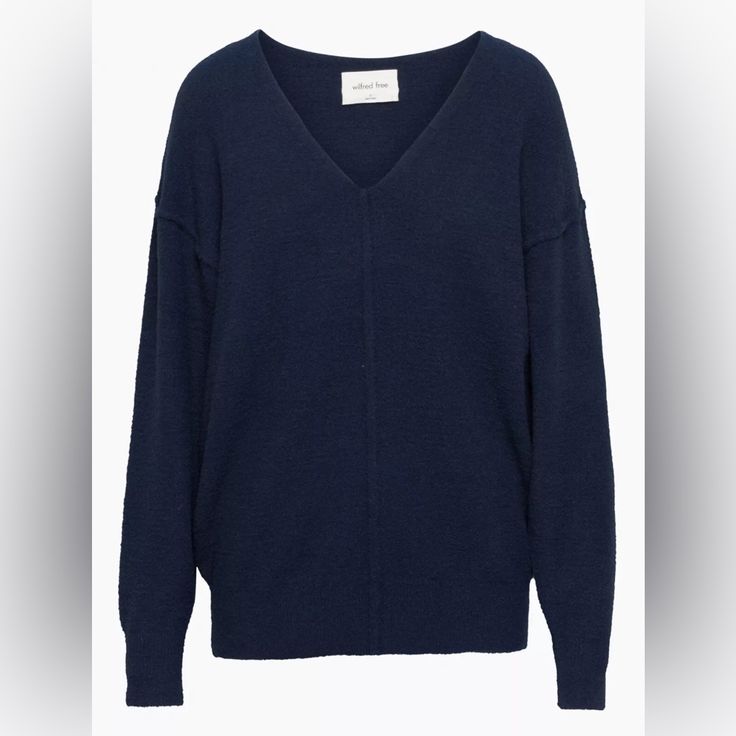 a blue sweater is shown on a hanger and it has a white tag in the middle