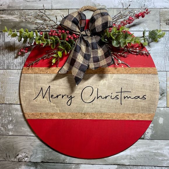 a christmas ornament hanging on the side of a wooden wall with a bow