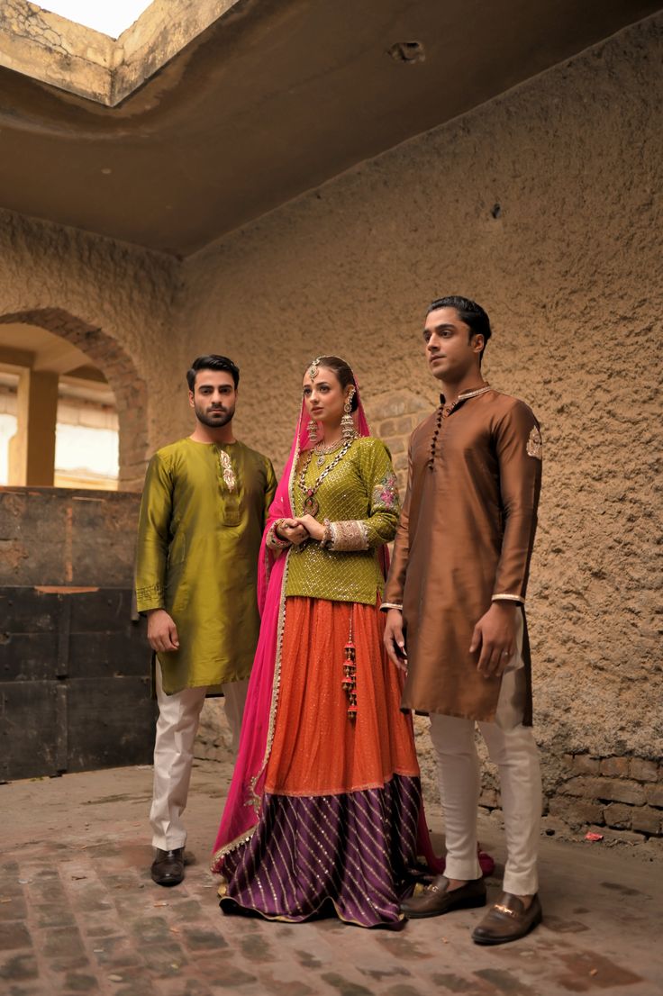 A brown silk kurta and fitted plain cotton silk pajama with gold embroidery on collar and sleeves and a matching motif on the arms, with round buttons to compliment the traditional look. Model wears a size Small. Traditional Long Sleeve Sharara With Naqshi, Traditional Sharara With Naqshi Embroidery, Traditional Raw Silk Lawn Suit For Eid, Sharara With Naqshi For Traditional Ceremonies And Festivals, Traditional Naqshi Sharara For Eid, Festival Raw Silk Lawn Suit With Naqshi, Traditional Raw Silk Wear With Naqshi Detailing, Traditional Naqshi Raw Silk Traditional Wear, Anarkali Kurta With Dabka For Traditional Ceremonies