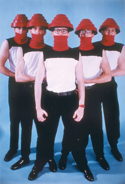 a group of men with red bandanas on their heads standing in front of a blue background