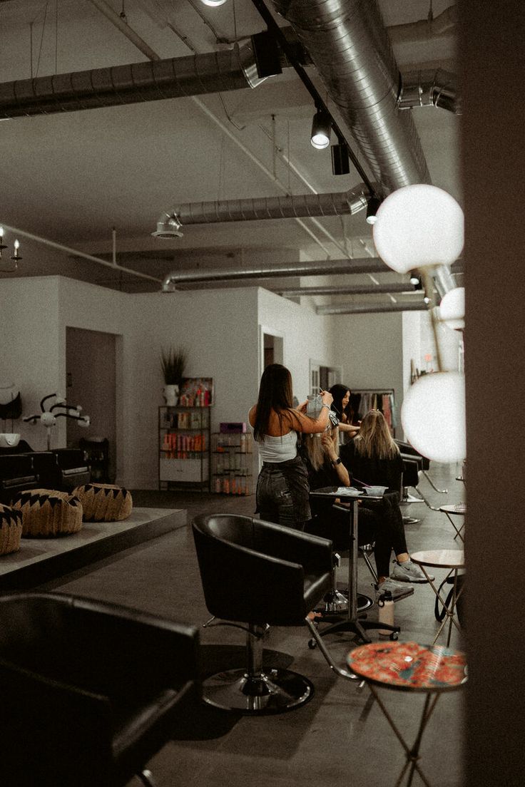 two women sitting in chairs at a hair salon