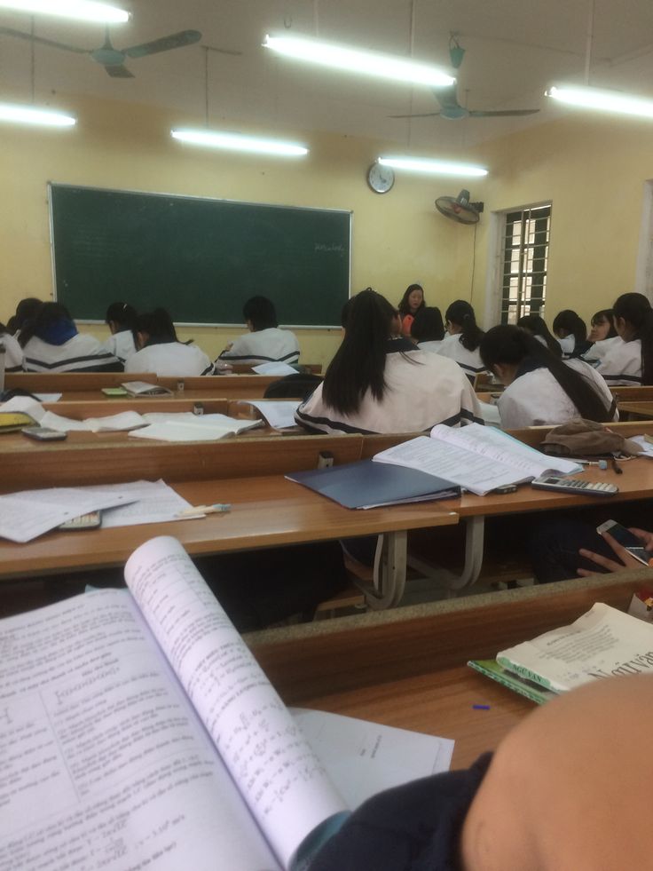 students are sitting at their desks in a classroom with books and papers on the desk