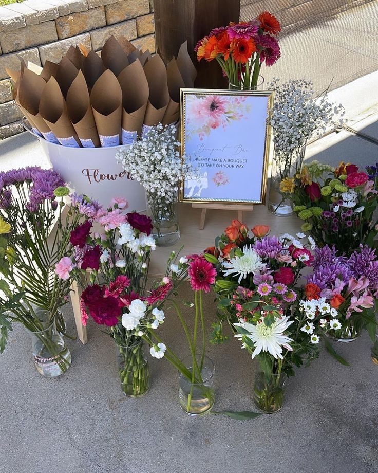 there are many vases with flowers in them on the table next to each other