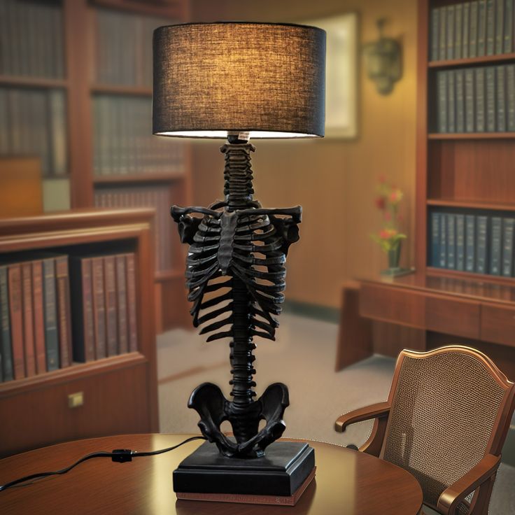 a skeleton lamp sitting on top of a wooden table next to a book case filled with books