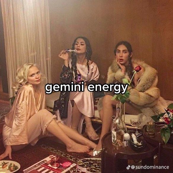 three beautiful women sitting on the floor in front of a table with food and drinks