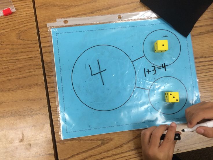 a person is playing with some dices on a board that has been cut out