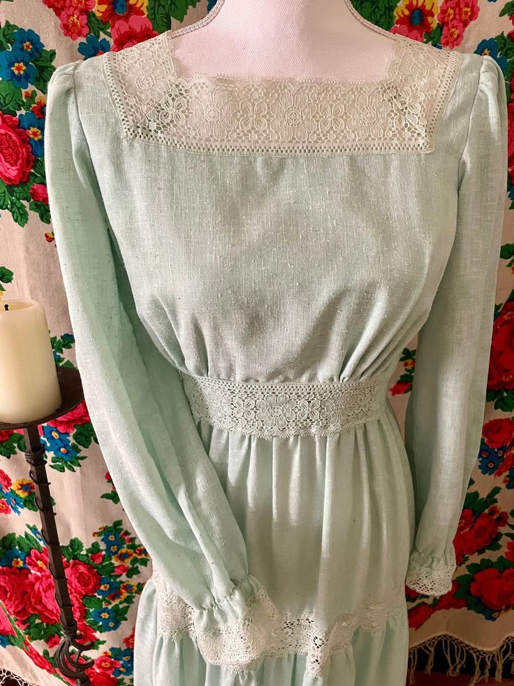 "70s Sears Mint Green Prairie Dress Beautiful romantic peasant dress with lace and ruffles. I feel like a forest nymph wearing her 🌳 Zip closure in the back and two hook-and-eyes. Tag says size 10 but please refer to measurements for accurate fit! Measurements with garnment lying FLAT (double for full measurement) : Shoulder to shoulder 15\" Pit to pit 17\" Waist 12\" Sleeve 22\" Shoulder to waist seam 15\" Skirt 40\" Total length 55\" In great vintage condition except a baby stain in the front of the skirt. INSTAGRAM @mina.manoush Follow on Ig to get the first pick of items CHEAPER before they're listed! PLEASE NOTE : When you are buying a vintage item, you are buying a piece that has had many lives before. They will not be in a perfect condition and may have pin holes, age spots and pre Spring Dress With Lace Collar And Square Neck, Fitted Peasant Dress With Square Neck For Spring, Spring Peasant Dress For Garden Party, Cottagecore Long Sleeve Vintage Dress For Summer, Cottagecore Vintage Dress With Long Sleeves For Summer, Retro Spring Dress With Smocked Bodice, Retro Swiss Dot Dress For Spring, Vintage Flowy Dress With Square Neck, Flowy Vintage Dress With Square Neck