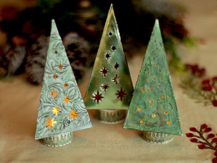 three small christmas trees sitting on top of a table