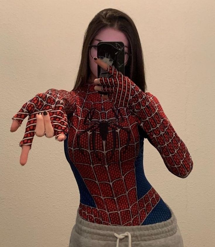 a woman taking a selfie in front of a mirror wearing a spiderman costume