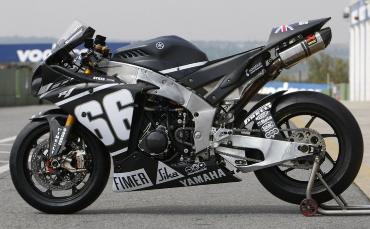 a black and white motorcycle parked on the side of a road next to a building