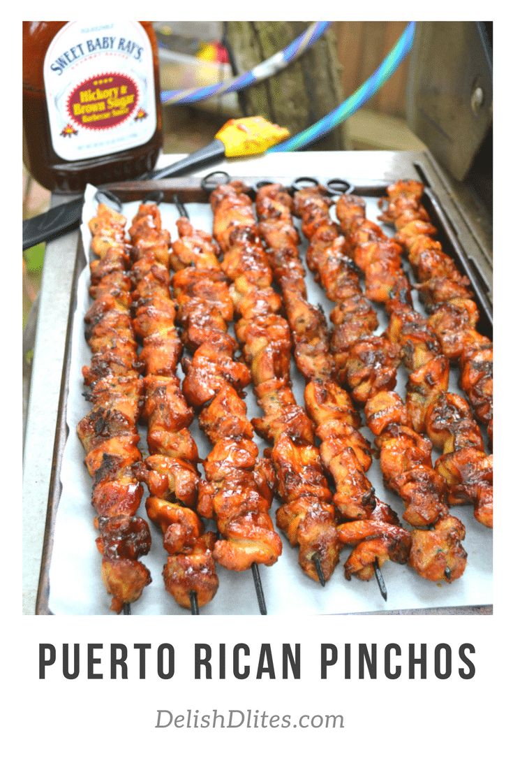 bbq chicken skewers on a grill with barbecue sauce next to it and a bottle of ketchup