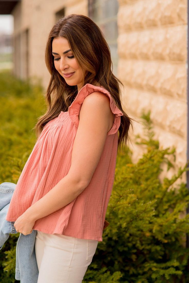 a woman in white pants and a pink top