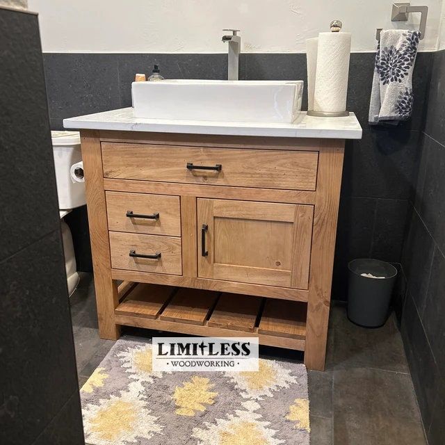 a bathroom with a sink, toilet and rugs on the floor in front of it