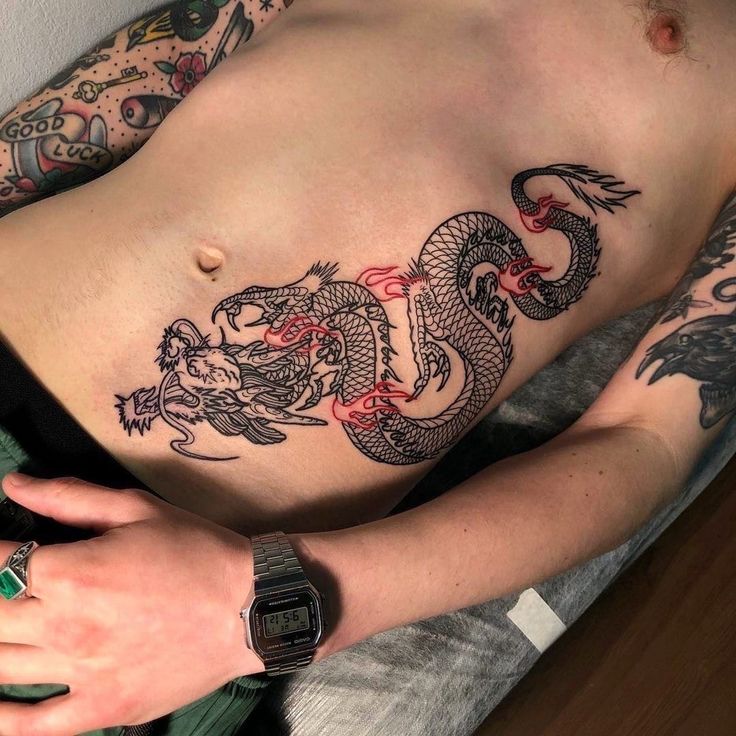 a man with tattoos on his stomach and chest is holding a cell phone in his hand