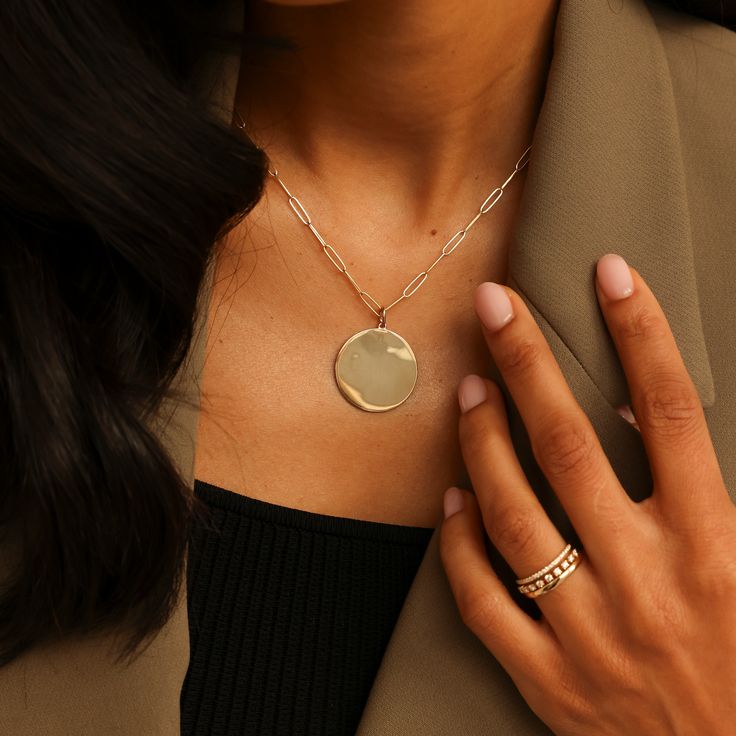 Our sleek and stylish DRD Paperclip Disc Charm Necklace adds modern sophistication to any look. The large, polished gold pendant pairs cleanly with our coveted 14 karat gold paperclip chain. This wear-with-everything necklace is a timeless addition to any neck stack. Want to make it more personal? Add engraving, or your favorite charms to make this piece truly unique! 14 Karat Gold Disc is 25.2mm in Diameter Adjustable Length 20" Paperclip Chain To add a heart to your engraving, use "*" in the text box above. Please note engraving will add up to 10 days to delivery time To add a custom charm, please email info@danarebeccadesigns.com Additional Charms Sold Separately 14k Gold Paperclip Chain Chain Length: 20" Links Measure 9.9mm x 2.5mm Lobster Clasp Sleek Jewelry Gift, Sleek Round Jewelry For Gift, Minimalist Jewelry With Polished Oval Link, Minimalist Yellow Gold Jewelry With Paperclip Chain, Modern Gold-plated Jewelry With Paperclip Chain, Minimalist Yellow Gold Paperclip Chain Jewelry, Modern Gold Chain Necklace With Polished Finish, Minimalist Yellow Gold Paperclip Necklace, Luxury Yellow Gold Jewelry For Workwear